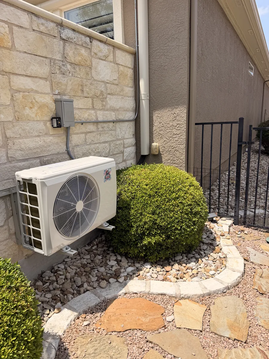 Condenser unit freshly installed against board-and-batten siding